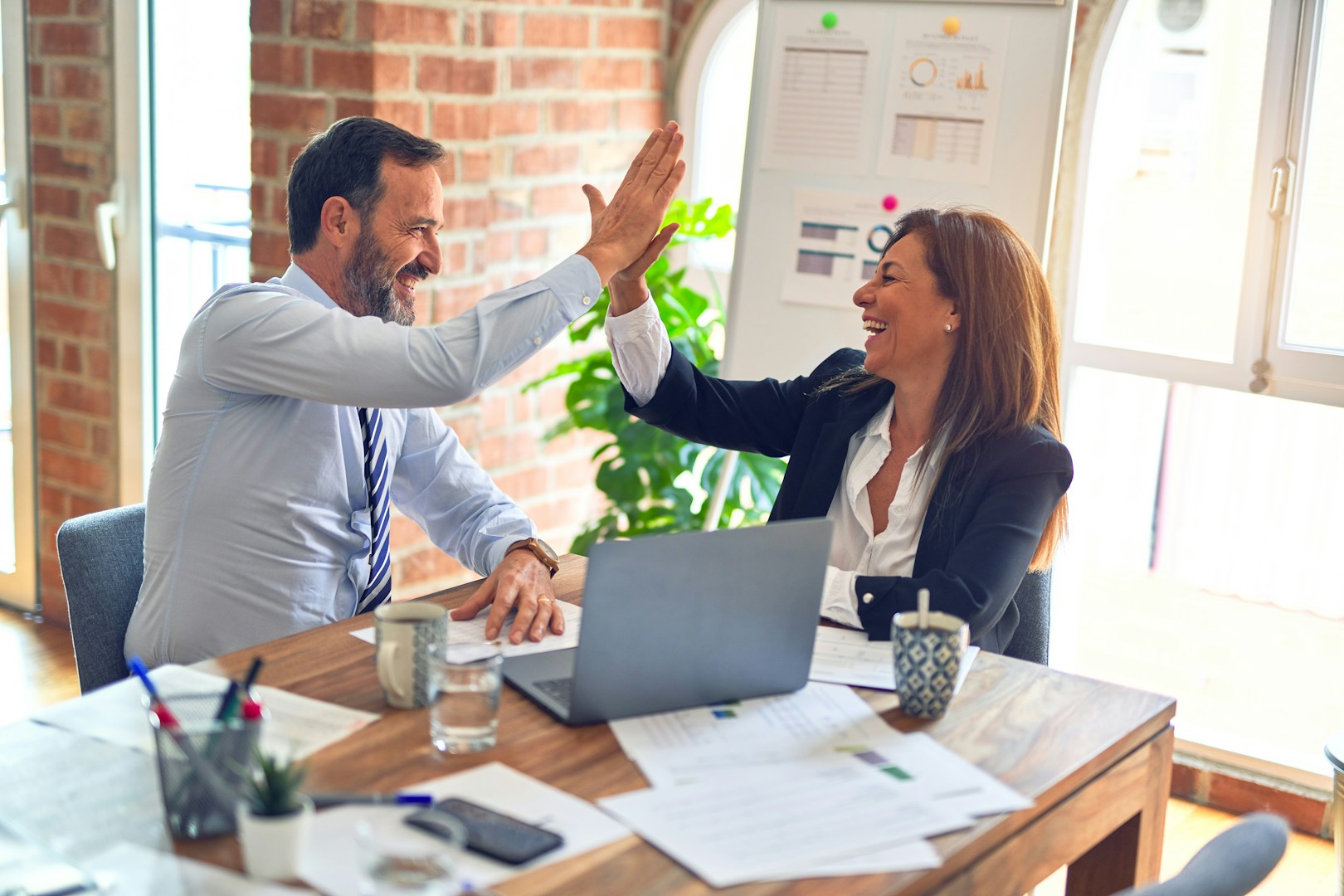 Happy employees and employer high-fiving